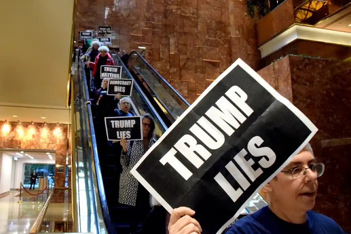 Photo of people carrying anti-Trump signs during a protest at Trump Tower